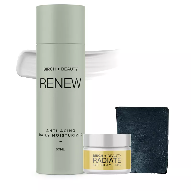 Birch + Beauty skincare with anti-aging moisturizer and eye cream on stone backdrop.